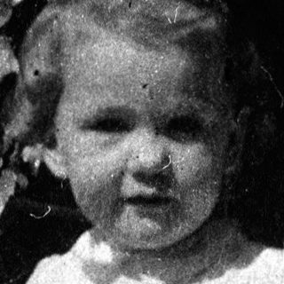 Young girl in vintage dress posing outdoors.