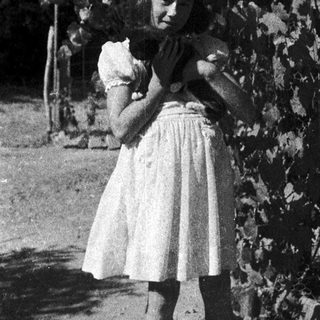 Young girl hugging a stuffed animal outdoors.