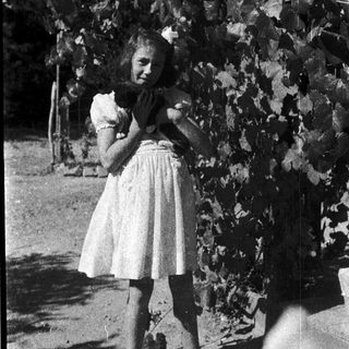 Young girl hugging a stuffed animal outdoors.