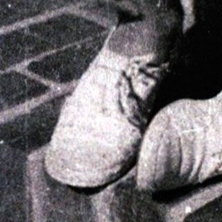 Young boy sitting on brick steps smiling.