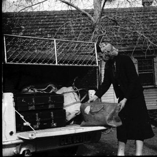 Two people loading luggage into a truck.