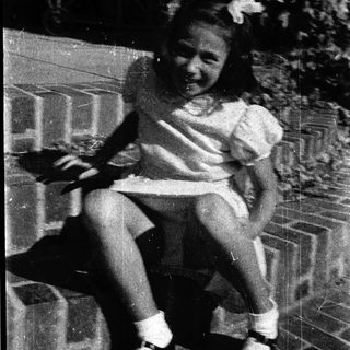 Young girl sitting on swing outdoors.
