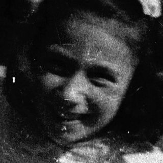 Young girl sitting on swing outdoors.