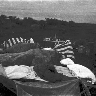 Camp bedding setup in outdoor field.