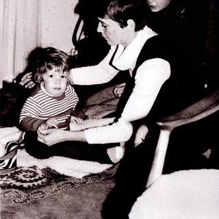 Family members interacting indoors, focusing on a young child.