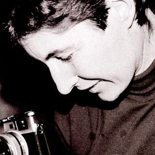 Person examining old photographs with vintage camera.