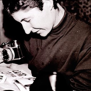 Person examining old photographs with vintage camera.