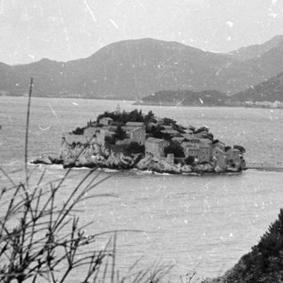 Island fortress surrounded by mountainous coastline.