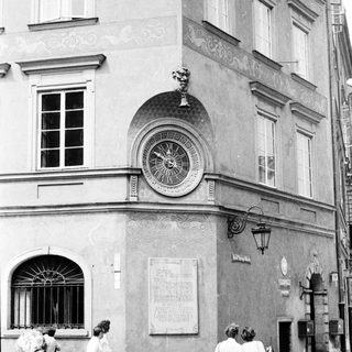 Historic building exterior with clock and pedestrians.