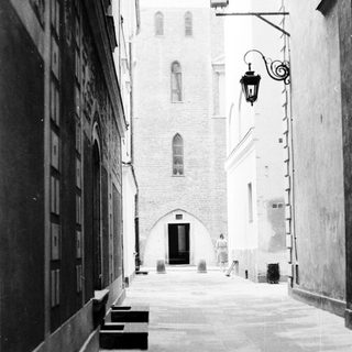 Narrow alleyway with historic stone buildings and lantern.