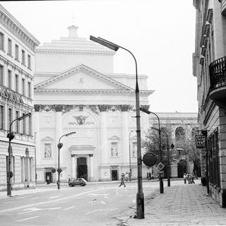 Neoclassical building facade on city street corner.