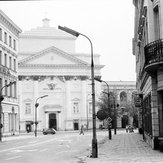 Neoclassical building facade on city street corner.