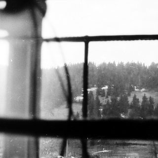 View of snow-covered landscape through frosted window.