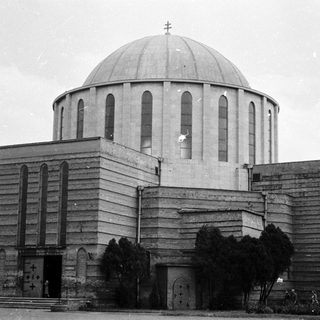 Modernist church with large dome and concrete architecture.