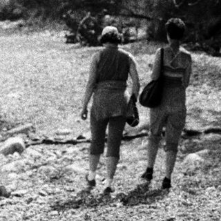 Two people hiking on a rocky trail.