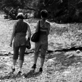 Two people hiking on a rocky trail.