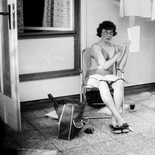 Woman sitting outside writing by door.