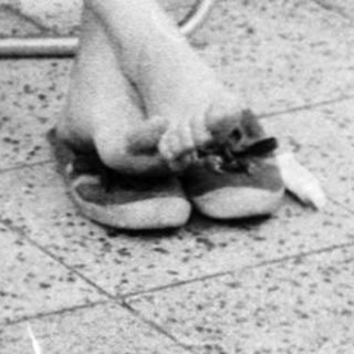 Woman sitting outside writing by door.