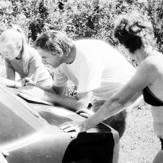 People repairing or adjusting a sailboat.