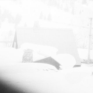 Snow-covered landscape with partially buried structure.