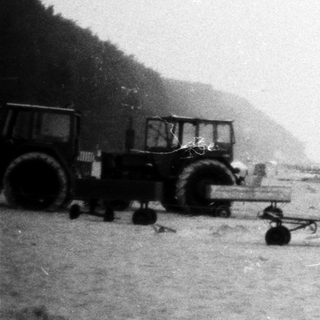 Beached fishing boat with tractor and equipment.