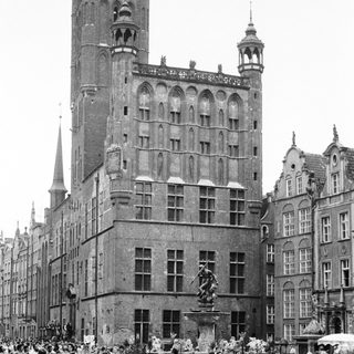 Historic European town square with Gothic architecture and statue.