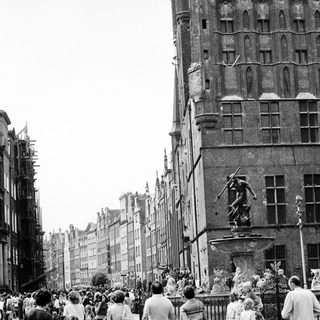 Historic European city street with crowded pedestrian area.
