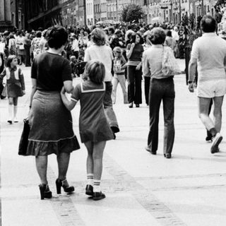 Historic European city street with crowded pedestrian area.