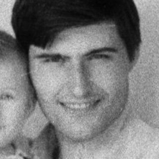 A man holding a smiling baby indoors.