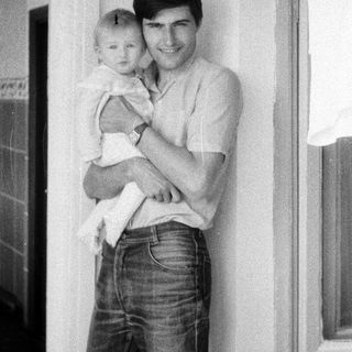 A man holding a smiling baby indoors.