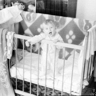 Baby crying in a crib.