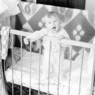 Baby crying in a crib.