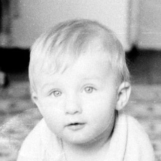 Baby crawling on floor with toys.