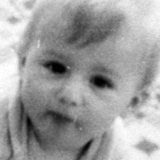 Baby crawling on patterned floor mat.