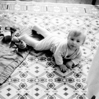 Baby crawling on patterned floor mat.