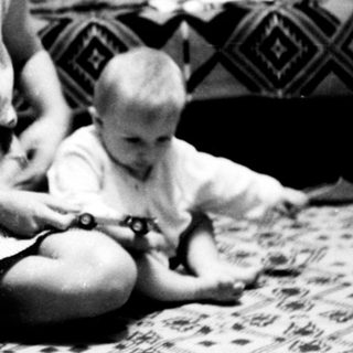 Woman and toddler playing indoors together.