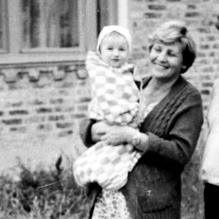 Family portrait with mother holding baby outdoors.