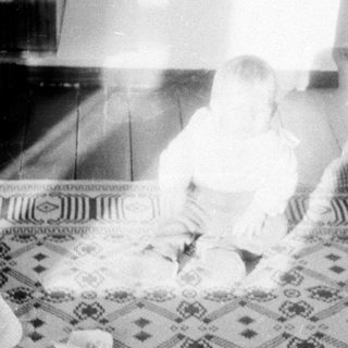 Baby playing on patterned floor mat.