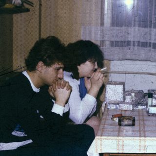 Three people sitting indoors, engaged in conversation.