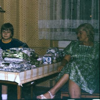 Group gathered around wrapped gift boxes indoors.