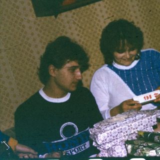 People playing cards indoors on a bed.