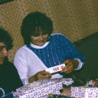 People playing cards indoors on a bed.