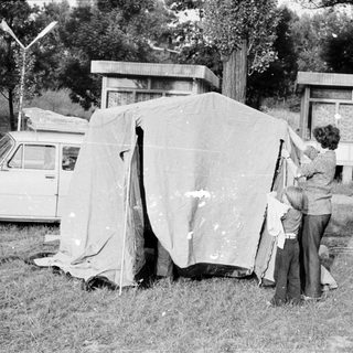 People setting up a tent near a car.
