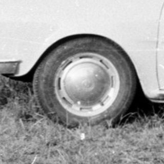 People setting up a tent near a car.