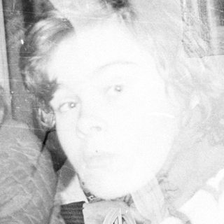 Vintage photo of elderly woman holding young child indoors.