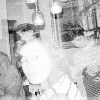 Vintage photo of elderly woman holding young child indoors.