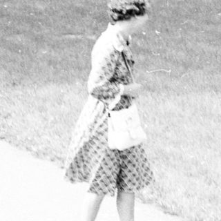 A woman walks alone on a path.