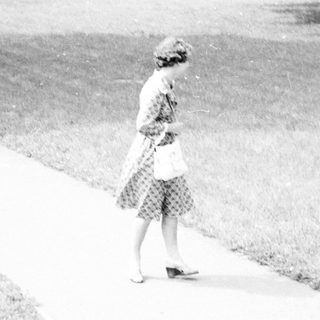 A woman walks alone on a path.