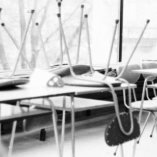 Empty classroom with desks, chairs, and standing microphones.