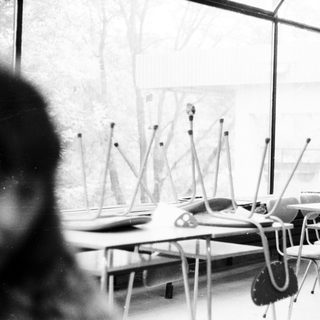 Empty classroom with desks, chairs, and standing microphones.